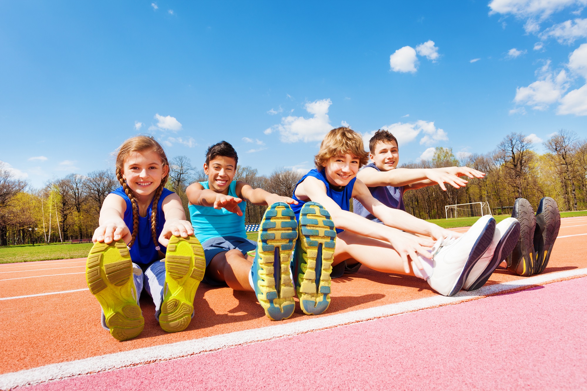 Happy kids stretching on an athletics track