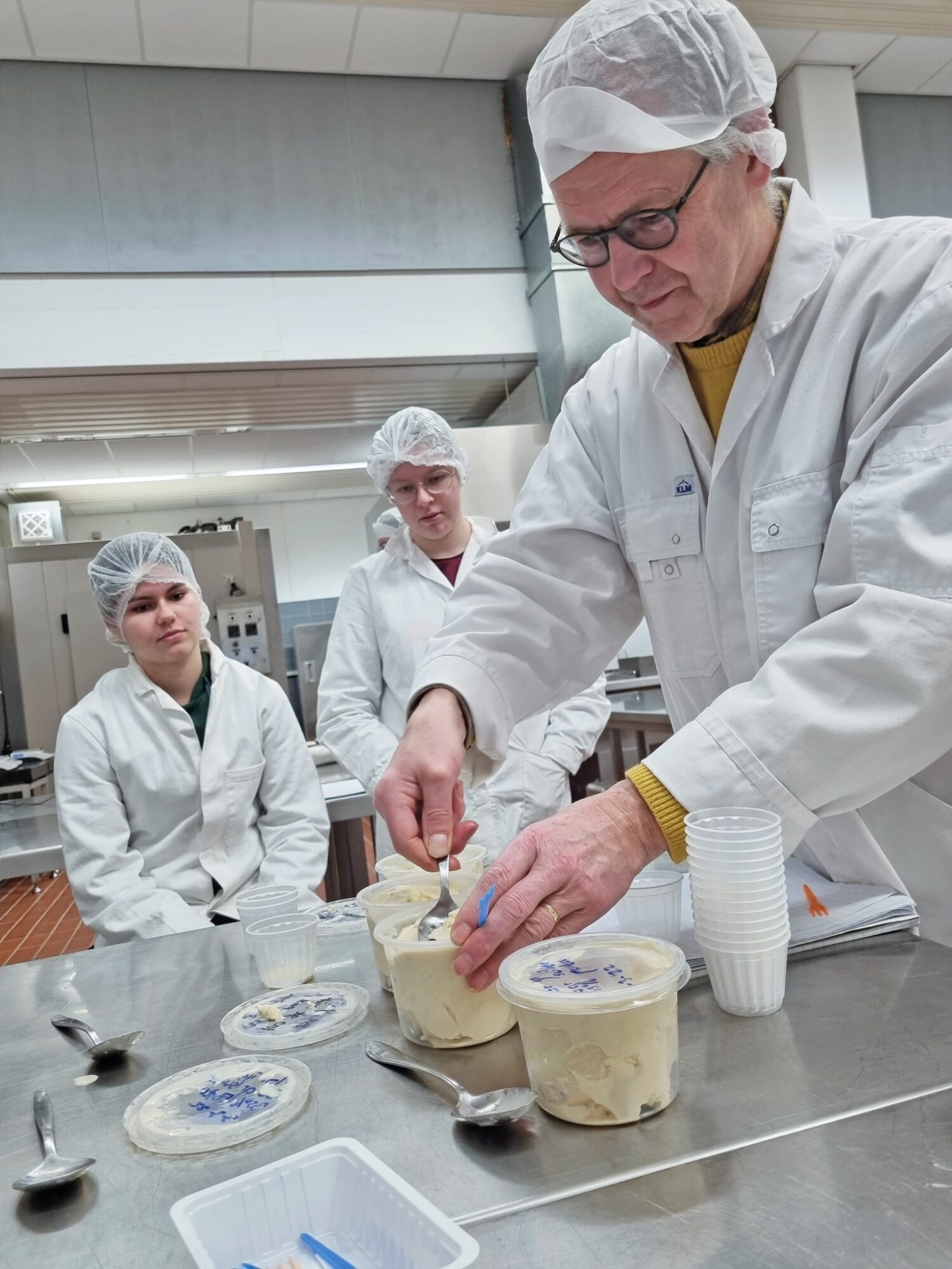 3 people in lab coats working on bread paste